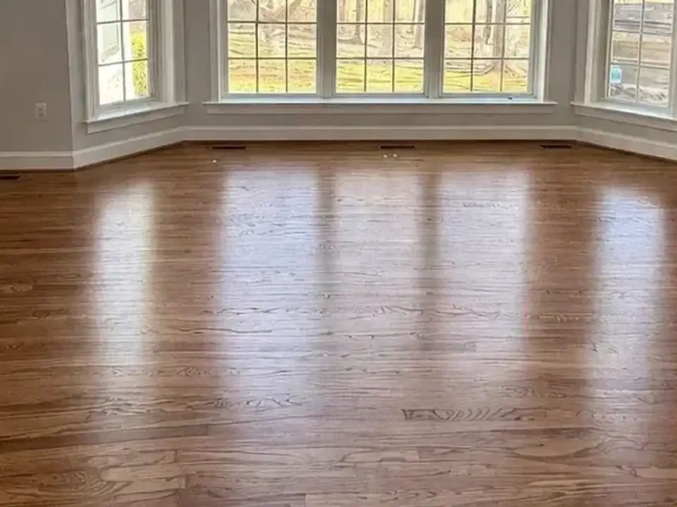 After: the same room empty with clean hardwood floors
